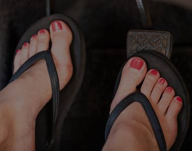 Summer feet driving a car in flip flop shoes